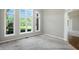 Bright living room featuring neutral walls, carpet floors, and large windows with views of the outdoors at 6183 Whitetail Run, Greenwood, IN 46143
