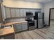 Modern kitchen featuring stainless appliances, wood countertops, and gray cabinetry at 624 Warren Ave, Indianapolis, IN 46221