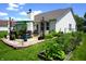 The backyard features a paver patio with a table, chairs, and an umbrella, plus garden beds at 6422 Hollingsworth Dr, Indianapolis, IN 46268