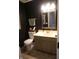 Stylish powder room featuring dark walls, a modern mirror, and a sleek vanity at 6422 Hollingsworth Dr, Indianapolis, IN 46268