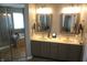 Well-lit bathroom with double sinks, decorative mirrors, and a view of the bathtub and shower area at 6422 Hollingsworth Dr, Indianapolis, IN 46268