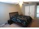 A bedroom with a ceiling fan and dinosaur-themed bedding features a double door closet for storage at 6422 Hollingsworth Dr, Indianapolis, IN 46268