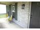 Inviting front porch with two yellow chairs and gray brick facade and front door at 6422 Hollingsworth Dr, Indianapolis, IN 46268