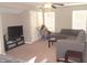 Cozy living room with gray sectional couch, television and entertainment stand with large windows allowing ample light at 6422 Hollingsworth Dr, Indianapolis, IN 46268