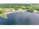 Stunning aerial view of a lake with a sandy beach and boat docks surrounded by lush greenery at 6497 Osprey Dr, Nineveh, IN 46164