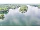 Expansive aerial view of a lake showcasing pristine blue waters and lush green wooded shores, perfect for nature lovers at 6497 Osprey Dr, Nineveh, IN 46164