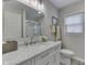 Bright bathroom with a white marble vanity, shower, and soft-close toilet beneath a bright vanity mirror at 6497 Osprey Dr, Nineveh, IN 46164