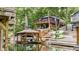 Exterior lake house view featuring boat dock and deck, surrounded by lush greenery at 6497 Osprey Dr, Nineveh, IN 46164
