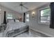 Serene main bedroom featuring a rustic bed frame, fan, and light-filled windows at 6497 Osprey Dr, Nineveh, IN 46164