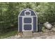 Charming blue outbuilding offering extra storage, complemented by natural surroundings, great for a functional backyard at 6497 Osprey Dr, Nineveh, IN 46164