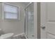 Updated bathroom with a glass enclosed shower with a white surround, a window, and gray vinyl floors at 6497 Osprey Dr, Nineveh, IN 46164