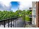 A private balcony with black metal railings overlooks mature trees and blue skies at 6556 Reserve Dr, Indianapolis, IN 46220