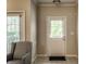 Bright entryway with white door, neutral walls, patterned chair, and tile floors creates a welcoming first impression at 6556 Reserve Dr, Indianapolis, IN 46220