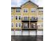 Exterior of a yellow townhouse featuring balconies, garages and covered parking at 6556 Reserve Dr, Indianapolis, IN 46220