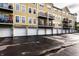 Exterior of a yellow townhouse featuring multiple balconies and garages with wet parking lot at 6556 Reserve Dr, Indianapolis, IN 46220