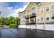 Exterior of a yellow townhouse featuring multiple balconies and garages in a landscaped community at 6556 Reserve Dr, Indianapolis, IN 46220