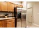 Functional kitchen with stainless steel refrigerator, wooden cabinets, and granite countertops, perfect for everyday cooking at 6556 Reserve Dr, Indianapolis, IN 46220