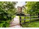 Gated entrance to property lined with mature landscaping and lush green grass at 6556 Reserve Dr, Indianapolis, IN 46220
