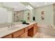 Bathroom featuring double sinks, a large mirror, garden tub, and glass-enclosed shower with bench at 6640 Page Blvd # 101, Indianapolis, IN 46220