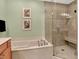 A well-lit bathroom showcases a garden tub with elegant fixtures and a glass-enclosed shower with a built-in bench at 6640 Page Blvd # 101, Indianapolis, IN 46220