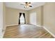 Neutral bedroom with hardwood floors, large window with dark curtains, and closet at 6640 Page Blvd # 101, Indianapolis, IN 46220