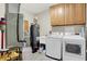 Functional laundry room featuring cabinets, tile flooring, and modern appliances at 6640 Page Blvd # 101, Indianapolis, IN 46220