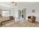 Bright main bedroom with wood floors, a ceiling fan, and a sliding glass door that provides backyard access at 6640 Page Blvd # 101, Indianapolis, IN 46220