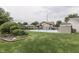 A lovely backyard featuring an in-ground pool, gazebo, lush landscaping, and a black chain link fence at 6649 Madison Ave, Indianapolis, IN 46227
