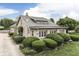 Beautiful stone home with a well-maintained front yard featuring manicured bushes and lush greenery at 6649 Madison Ave, Indianapolis, IN 46227