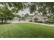 Expansive green lawn featuring a charming stone home with a detached three-car garage and basketball hoop at 6649 Madison Ave, Indianapolis, IN 46227