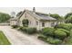 Well-maintained stone home featuring mature landscaping and a long driveway for ample parking at 6649 Madison Ave, Indianapolis, IN 46227