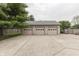 Three car garage with gray wood siding, concrete driveway and mature shade tree at 6649 Madison Ave, Indianapolis, IN 46227