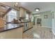 Functional kitchen with wood cabinets, granite countertops, stainless steel appliances, and wood-look floors at 6649 Madison Ave, Indianapolis, IN 46227