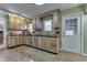 Eat-in kitchen with wooden cabinetry, stainless steel dishwasher, and view to backyard at 6649 Madison Ave, Indianapolis, IN 46227