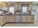 Eat-in kitchen featuring wooden cabinetry, stainless steel dishwasher, black counters, and tile backsplash at 6649 Madison Ave, Indianapolis, IN 46227