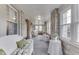 Bright sunroom with large windows, stone walls, wicker furniture, and carpet flooring at 6649 Madison Ave, Indianapolis, IN 46227