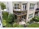 A lush backyard view displays a home's balcony and patio, surrounded by vibrant greenery and charming potted plants at 692 Greenford N Trl, Carmel, IN 46032