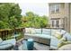 Inviting balcony featuring an outdoor sofa with green cushions, a blue ceramic stool, and a lush green backdrop at 692 Greenford N Trl, Carmel, IN 46032