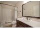 Bright bathroom featuring white tub, toilet, marble countertop with dark wood vanity, and framed mirror at 692 Greenford N Trl, Carmel, IN 46032