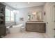 Luxurious bathroom with a freestanding tub, chandelier, double sink vanity with ornate mirrors, and neutral tile floors at 692 Greenford N Trl, Carmel, IN 46032