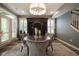 Dining room featuring unique lighting, gray walls, dark wood floors, and wine storage at 692 Greenford N Trl, Carmel, IN 46032