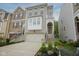 Charming townhome with a two-car garage, landscaped yard, and inviting front entrance and light colored brick at 692 Greenford N Trl, Carmel, IN 46032
