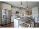 Elegant kitchen with stainless appliances, custom cabinets, granite counters, island, and hardwood floors at 692 Greenford N Trl, Carmel, IN 46032