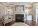 Living room with fireplace and built-in shelving; decorative painting and hardwood floors at 692 Greenford N Trl, Carmel, IN 46032