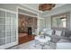 Bright living room with grey sofa, decorative pillows, and French doors, showcasing a glimpse into the next room at 692 Greenford N Trl, Carmel, IN 46032