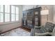 Bright home office with hardwood floors, white shutters, a classic black armoire, and a comfortable reading chair at 692 Greenford N Trl, Carmel, IN 46032