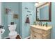 A powder bathroom decorated with soft blue walls, decorative mirror, and vanity with sink at 7047 Lancaster Ln, Avon, IN 46123
