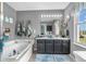 Bathroom with double vanity, a soaking tub, decorative towels, and natural light from the window at 7047 Lancaster Ln, Avon, IN 46123