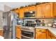 Well-lit kitchen showcasing stainless steel appliances and traditional wood cabinets, perfect for cooking and storage at 7047 Lancaster Ln, Avon, IN 46123