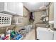 Functional laundry room with white cabinets, wire shelving, stainless steel washer, and space for organization at 7047 Lancaster Ln, Avon, IN 46123